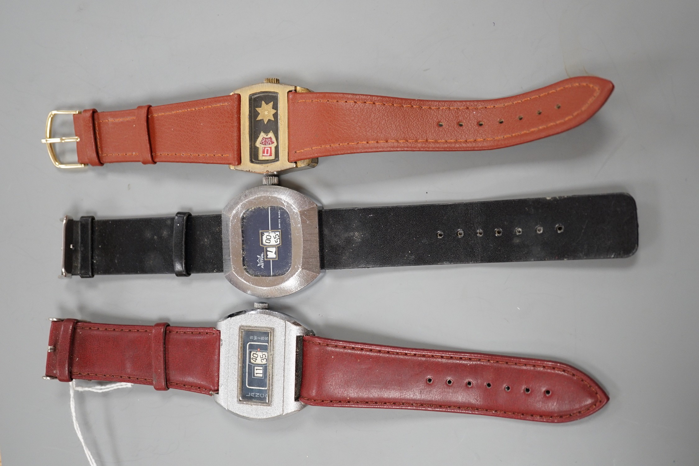 Three assorted steel or gilt steel jump hour digital manual wind wrist watches, including Astral and Lanco.